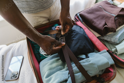 A man packing a suitcase on the bed photo