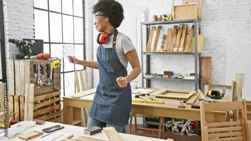 African american woman works in a workshop, surrounded by tools and wood. photo