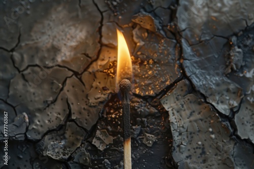 burning match against a textured grey burned surface