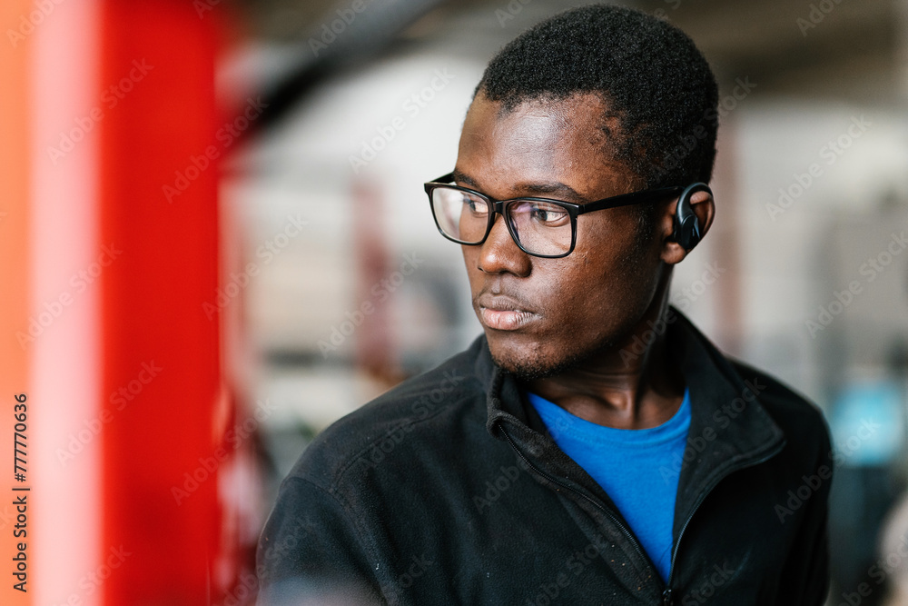 Black mechanic working at service station Black mechanic working at service station