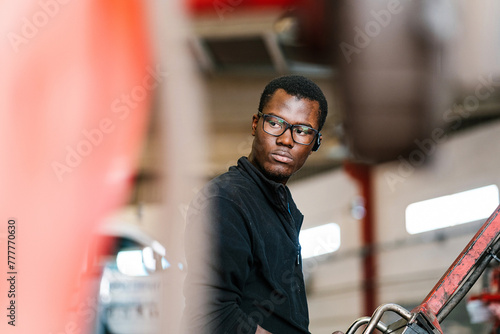 Black male worker operating industrial machine photo