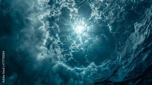 A look from under the water of the blue ocean to the sky with the sun with a large cloud in the sky. The sun shines brightly, creating a warm and cozy atmosphere.