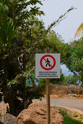Image of a sign prohibiting access to a path in a natural park in English, German and Spanish