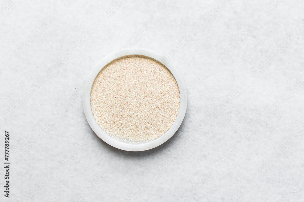Overhead view of instant yeast on a white tray, yeast granules for baking bread Overhead view of instant yeast on a white tray, yeast granules for baking bread