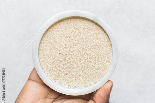 Overhead view of instant yeast on a white tray, yeast granules for baking bread