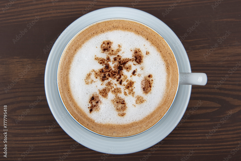 Cappuccino or latte with frothy foam, blue coffee cup top view closeup isolated on white background. Cafe and bar, barista art concept. Cappuccino or latte with frothy foam, blue coffee cup top view closeup isolated on white background. Cafe and bar, barista art concept.