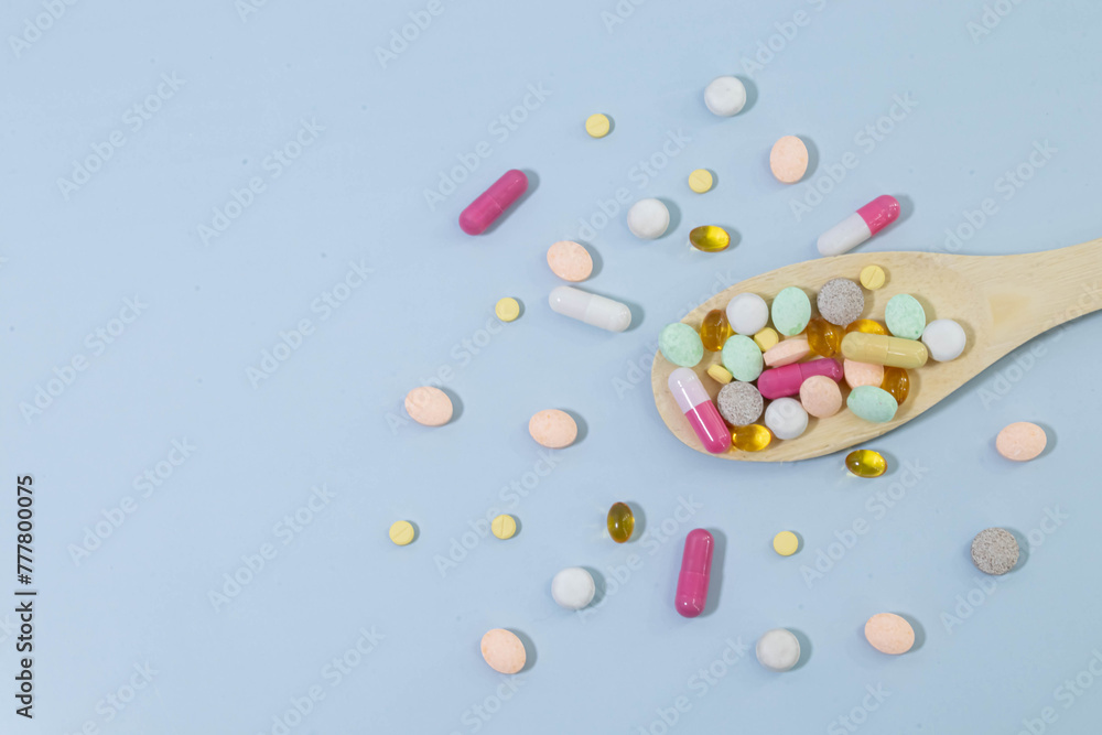 Scattered white pills on blue table. Mock up for special offers. Scattered white pills on blue table. Mock up for special offers.