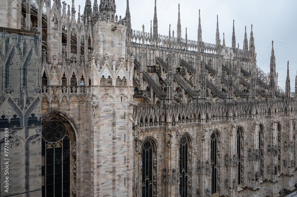 Architectural details of Gothic cathedral church in Milan, tourist attraction in northern Italy - obrazy, fototapety, plakaty 