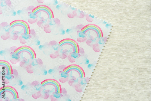 corner of fabric doily with rainbows and clouds print pattern on crepe paper