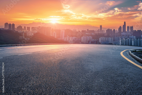 Empty asphalt road and modern city skyline with building scenery at sunset. high angle view. 