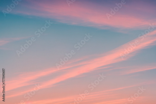 A pink and purple sky with clouds and a sunset in the background.