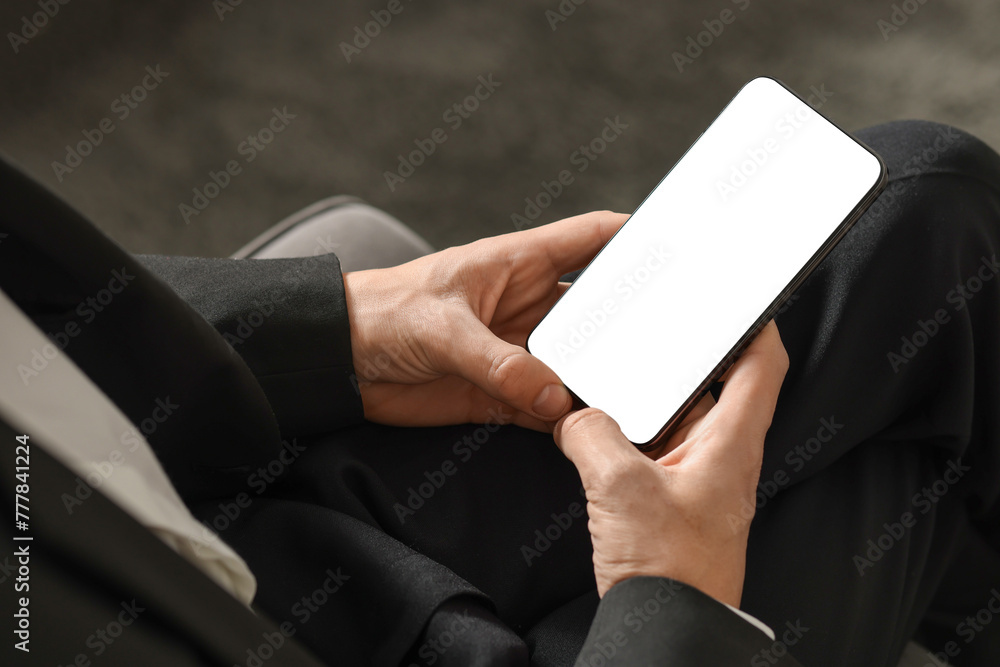 Man using smartphone with blank screen indoors, closeup. Mockup for design Man using smartphone with blank screen indoors, closeup. Mockup for design