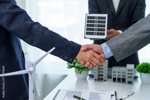 Two business professionals, both clad in suits, firmly shake hands, symbolizing mutual respect, agreement, and the successful culmination of a deal or partnership.