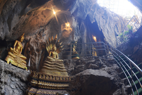 Buddha statues in various postures Enshrined in the famous Tham Khao Yoi Temple. And there are beautiful stalagmites and stalactites. Located at Petchaburi Province in Thailand. photo