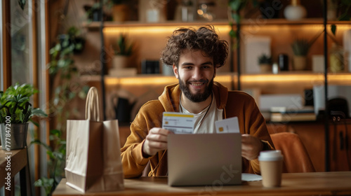 happy man using discount coupon on online purchases, using a laptop