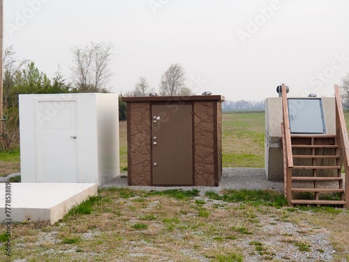 Three tornado shelters. The one on the right is buried, the other two are above ground. 