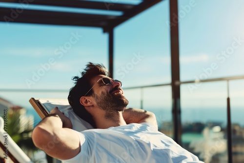 A man is relaxing on a lounge chair with his arms stretched out