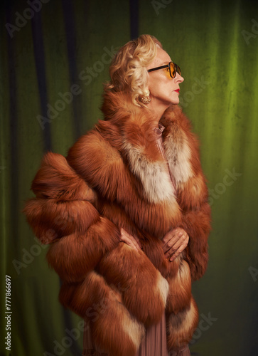 Senior beautiful woman in vintage style wearing a fur coat. photo