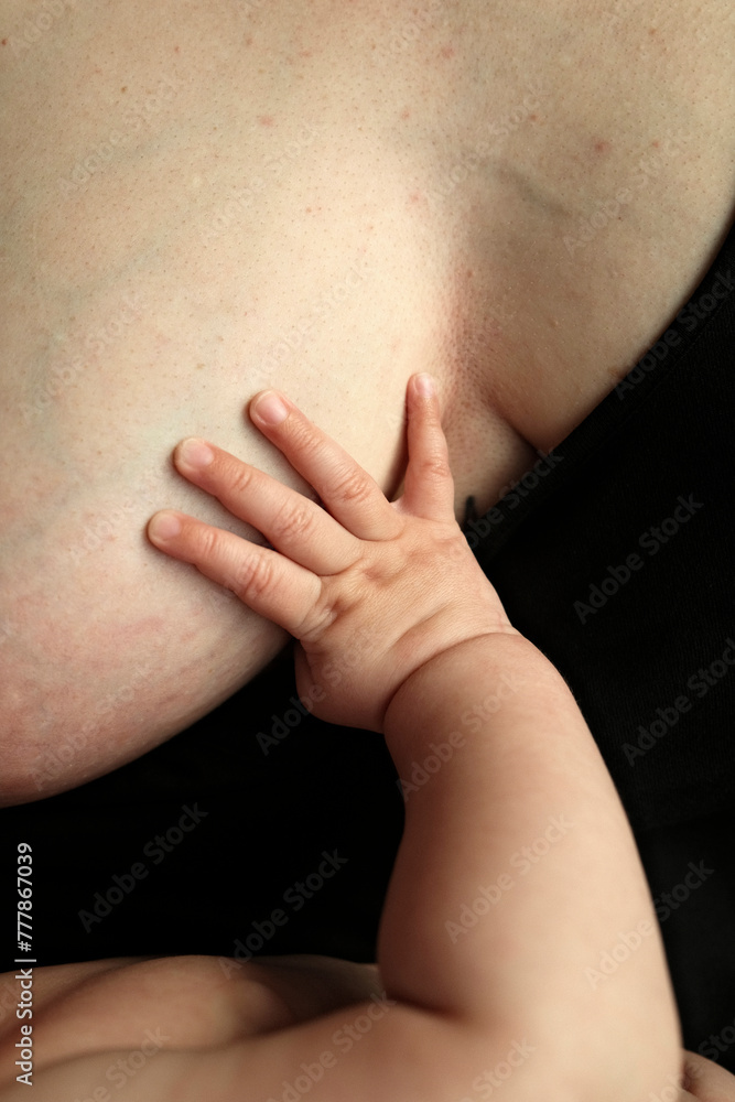 Child touching mother's breast Child touching mother's breast