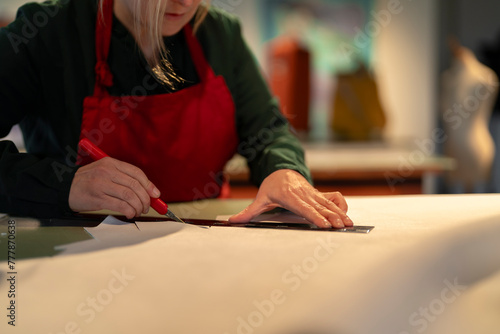 woman sitting and drawing on leather material at table photo