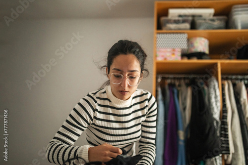 young woman tidying up her bedroom photo