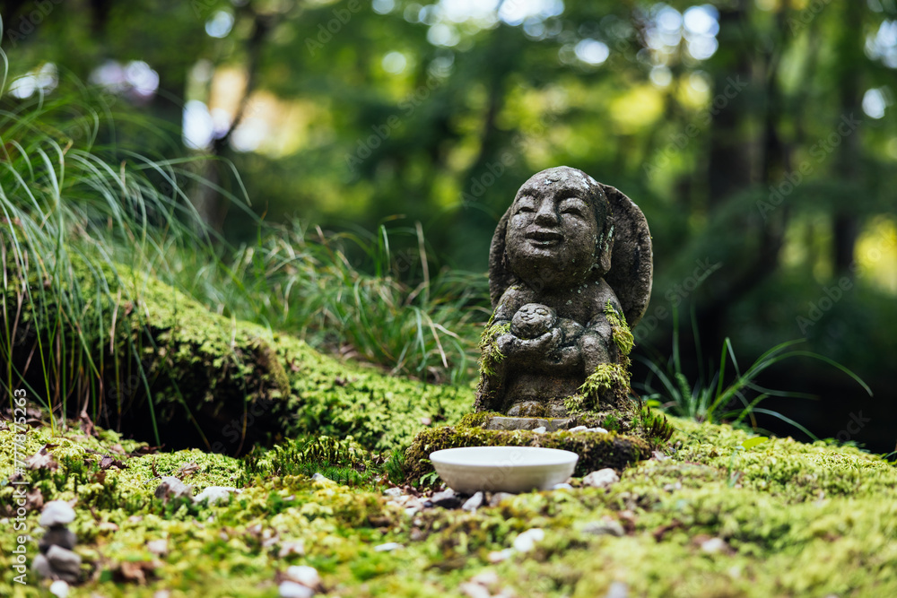 Stone Jizo Statue in Mossy Garden Stone Jizo Statue in Mossy Garden
