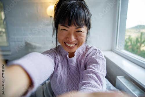 Closeup of cheerful woman taking selfie at home photo