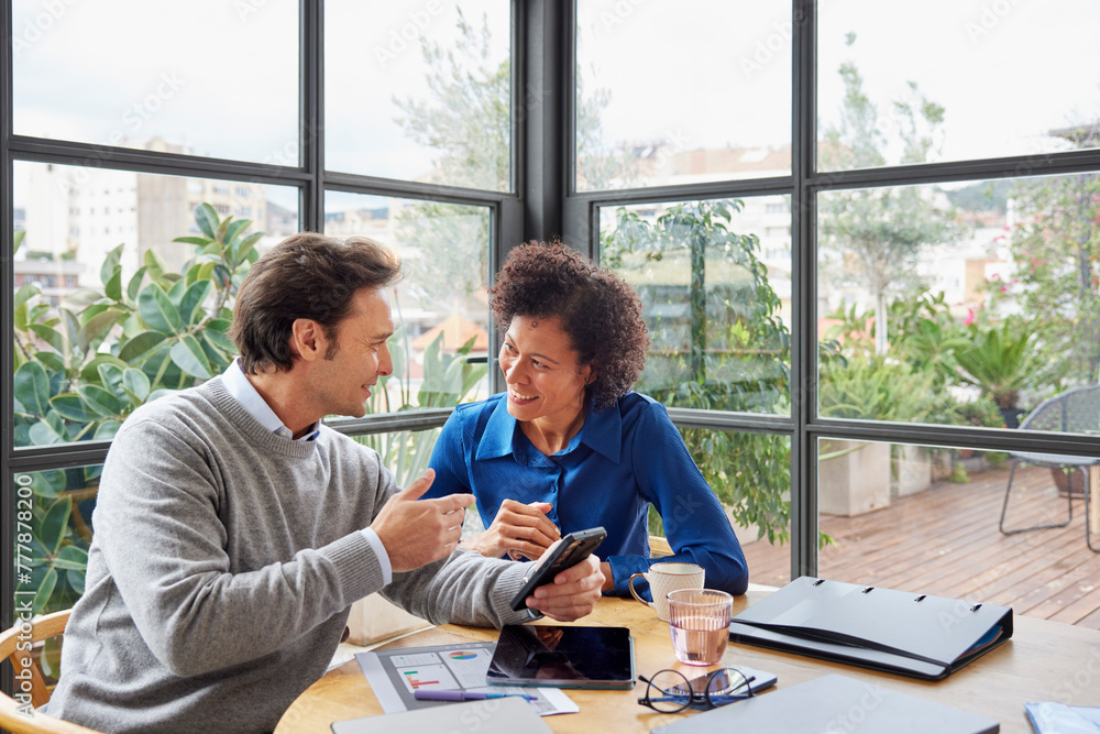 © ALTO IMAGES/Stocksy - Cheerful multiracial colleagues browsing cellphone