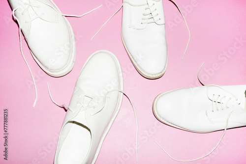 Classic white lace shoes/footwear on a pink background and flashlight photo