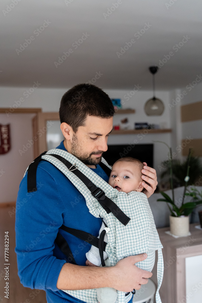 father with baby in sling at home on christmas eve father with baby in sling at home on christmas eve