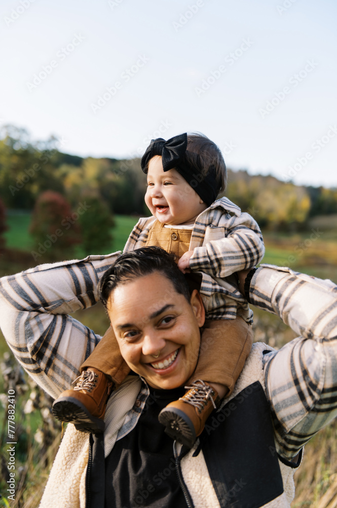 Happy smiling mother holding her baby daughter in arms in autumn. Happy smiling mother holding her baby daughter in arms in autumn.
