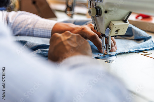Cropped image of tailor using sewing machine at workshop photo