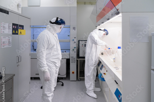 Two Scientists Working At Clean Room 