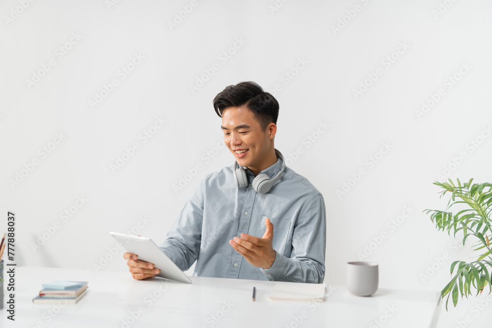 Happy Asian freelancer man working on tablet Happy Asian freelancer man working on tablet