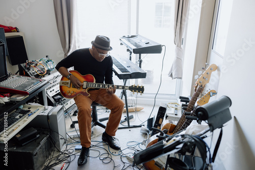 Man playing music in his studio room. photo