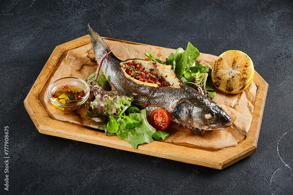Rainbow trout stuffed with vegetables and pomegranate seeds, accompanied by a salad, served on a wooden tray with a black background. A healthy, colorful dish that's a feast for the eyes Rainbow trout stuffed with vegetables and pomegranate seeds, accompanied by a salad, served on a wooden tray with a black background. A healthy, colorful dish that's a feast for the eyes