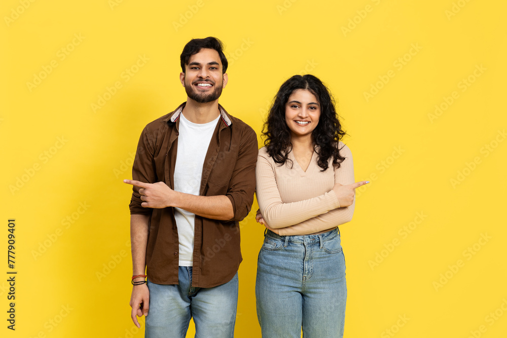 Couple Pointing To The Side On Yellow Background Couple Pointing To The Side On Yellow Background