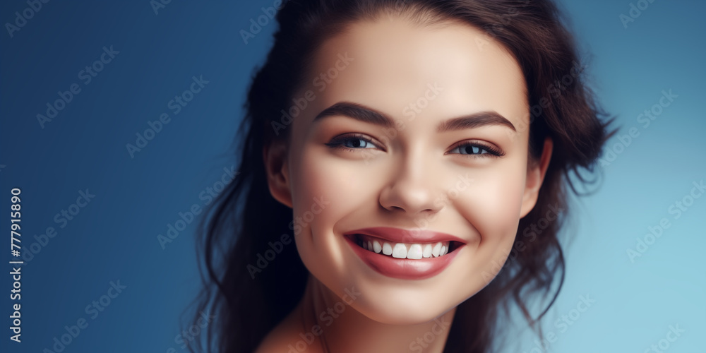 Portrait of Beautiful Smiling Young Woman on Blue Background. Beauty Girl with Healthy Clean Skin and Healthy Teeth. Teeth Whitening and Dentist Ttreatment. Beauty, Cosmetology and Spa concept Portrait of Beautiful Smiling Young Woman on Blue Background. Beauty Girl with Healthy Clean Skin and Healthy Teeth. Teeth Whitening and Dentist Ttreatment. Beauty, Cosmetology and Spa concept