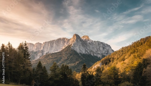 a majestic mountain formation the watzmann in bavaria germany with a colorful sunset sky and woodlands in the foreground
