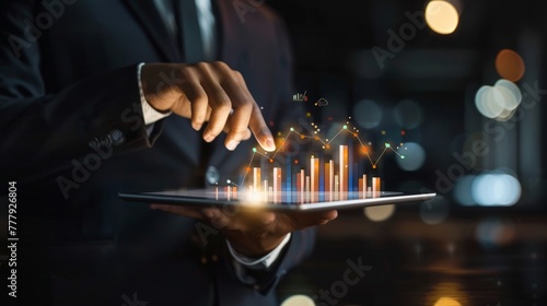 Businessman holding tablet analyzing sales data and economic growth graph chart,