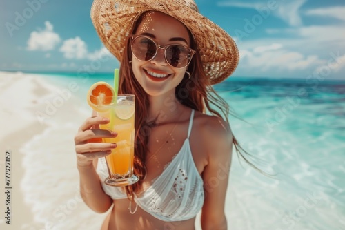 Close up portrait of a happy young woman with cocktail on the beach