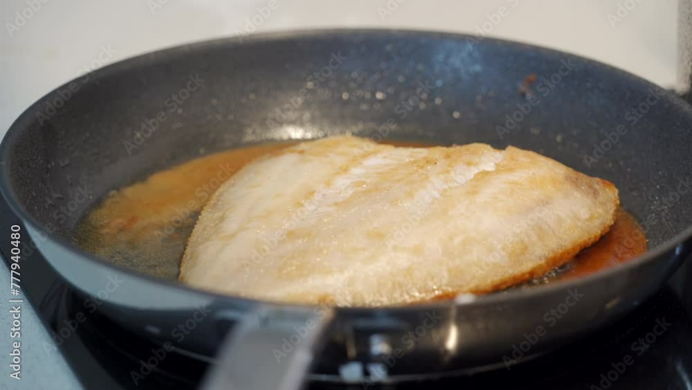 flounder fish is fried in a frying pan in the kitchen flounder fish is fried in a frying pan in the kitchen