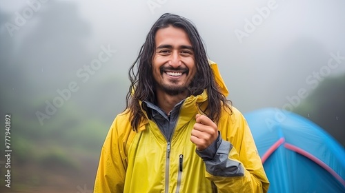 Happiness is being alone with yourself. A young Caucasian man enjoys a morning mug of coffee near his tent, alone with nature. Breath of the morning forest and the spirit of freedom