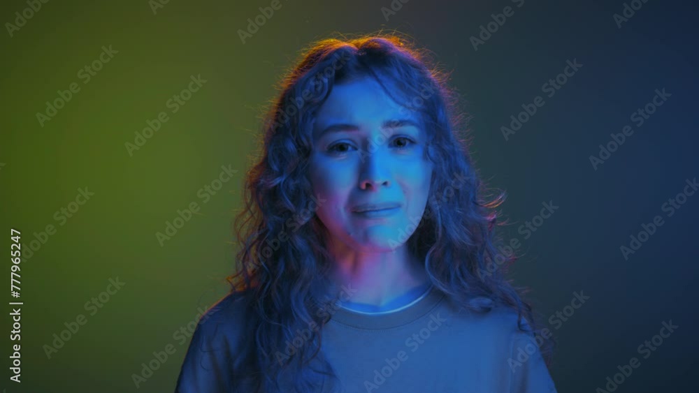 Sad Portrait of Young 20s Woman with Unhappy Face Looking at Camera in Colorful Neon Studio. Close Up Headshot of Crying Depressed Person with Bad Mood and Anxiety. Worry and Fears in Modern Lifestyle Sad Portrait of Young 20s Woman with Unhappy Face Looking at Camera in Colorful Neon Studio. Close Up Headshot of Crying Depressed Person with Bad Mood and Anxiety. Worry and Fears in Modern Lifestyle