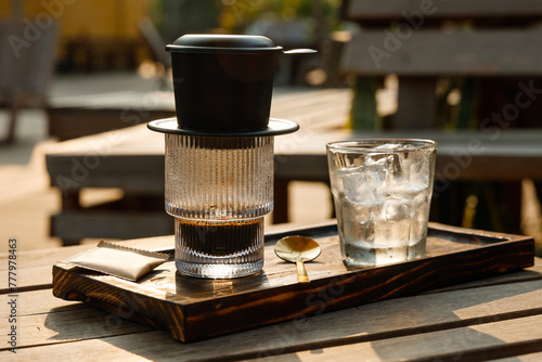 Vietnamese style coffee served on a wooden chopping block in an empty outdoor cafe