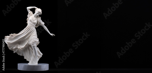 A classic white sculpture of a dancing woman positioned against a black background.