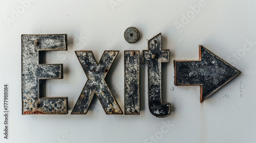 Rusty metal exit sign with arrow, against a white wall, creating a vintage directional concept. photo