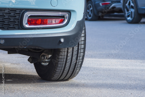 Close-up of car tires and wheel parked on asphalt roads.
