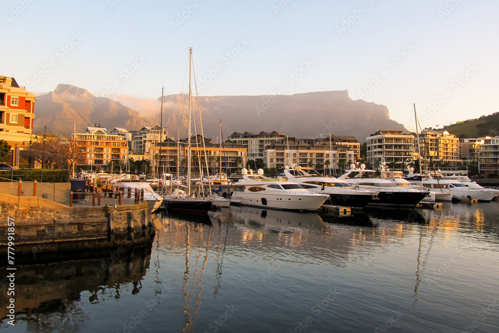 Fototapeta premium Expensive luxury boats in the marina at the V&A Waterfront, with Table Mountain in the Background, in the late afternoon, Cape Town, South Africa