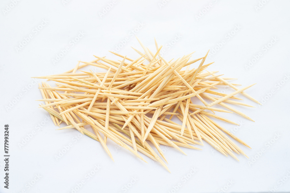 A heap of wooden toothpicks on white isolated background A heap of wooden toothpicks on white isolated background